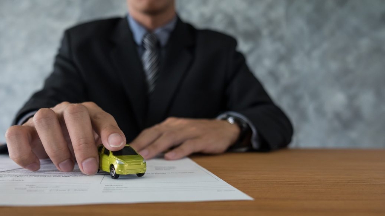 transportation and ownership concept - customer and salesman with car key